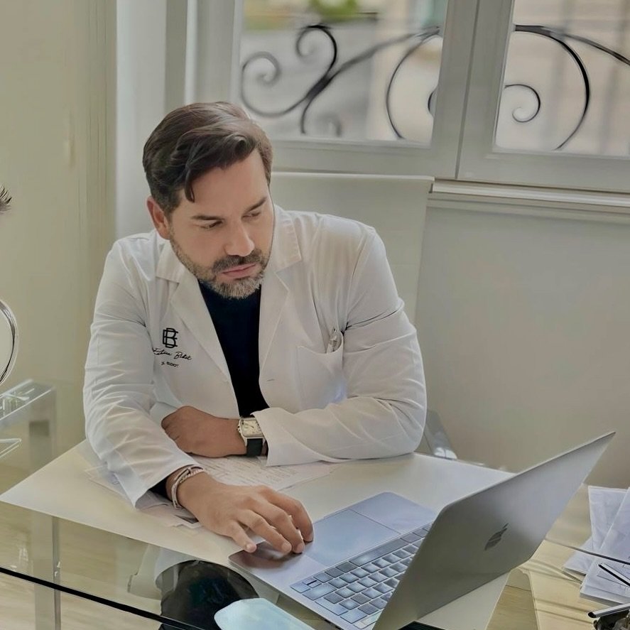 El Dr. Bidot revisa información en su ordenador en consulta.